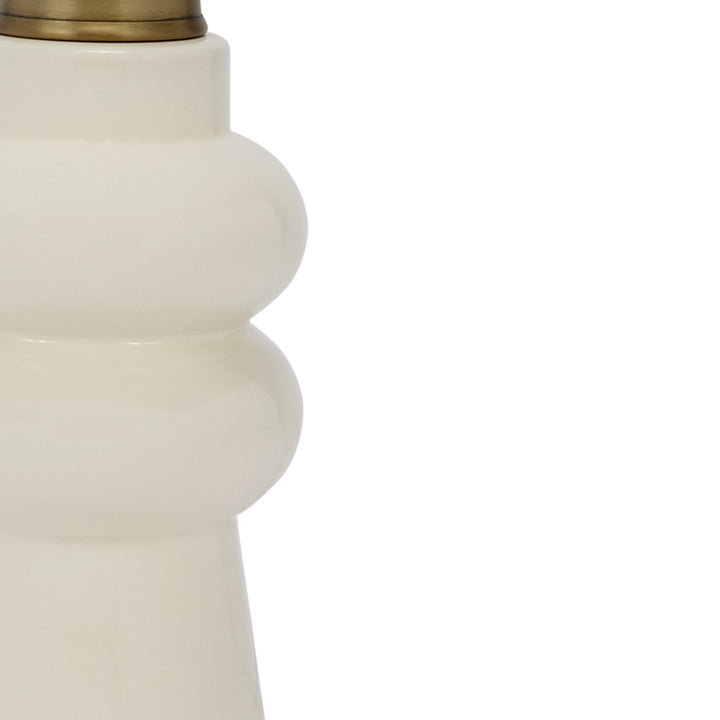 Cream ceramic lamp base close-up with stepped collar and brass neck cap