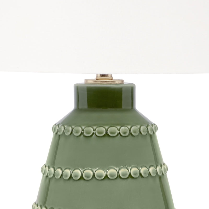 Green ceramic lamp base with beaded rings and brass-toned top hardware under white shade.