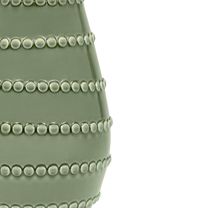 Green ceramic lamp base with detailed beaded row pattern, glossy finish close-up.