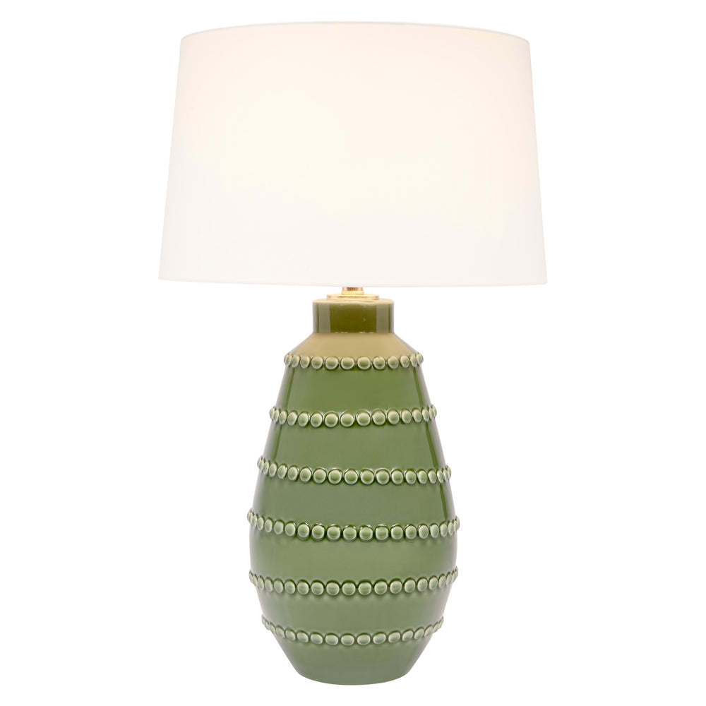 Green ceramic table lamp with white linen drum shade and stacked beaded bands on base.