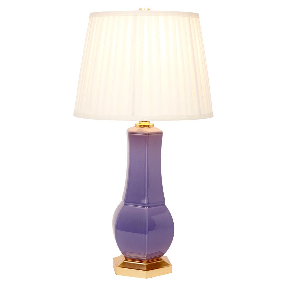 Lavender ceramic table lamp with white pleated shade, gold finial, and gold base