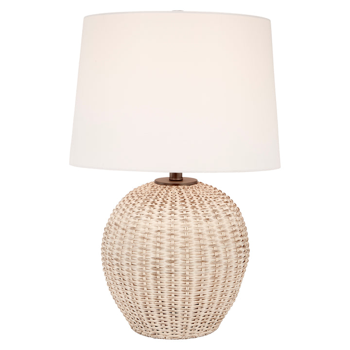 Table lamp with white linen drum shade atop rounded woven rattan body