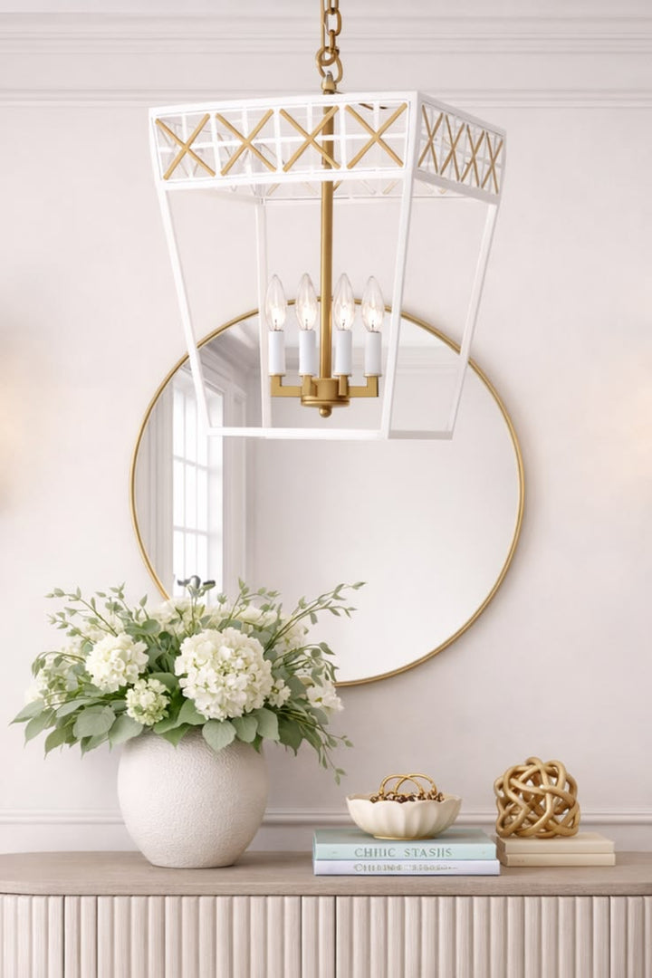 Decorative mirror with gold frame, hanging chandelier, and floral arrangement on a console table.