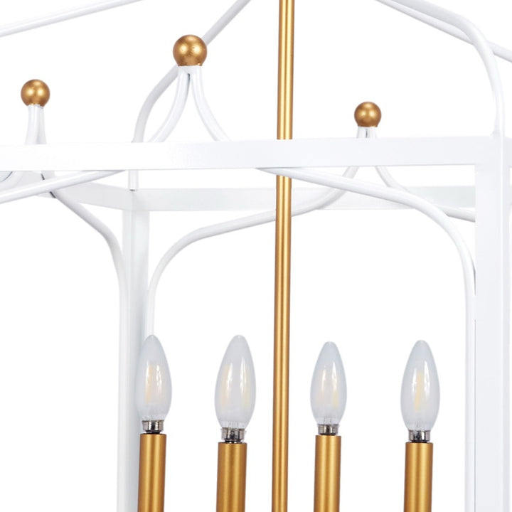 Pendant light close-up with white curved arms, gold ball finials, and four candle bulbs