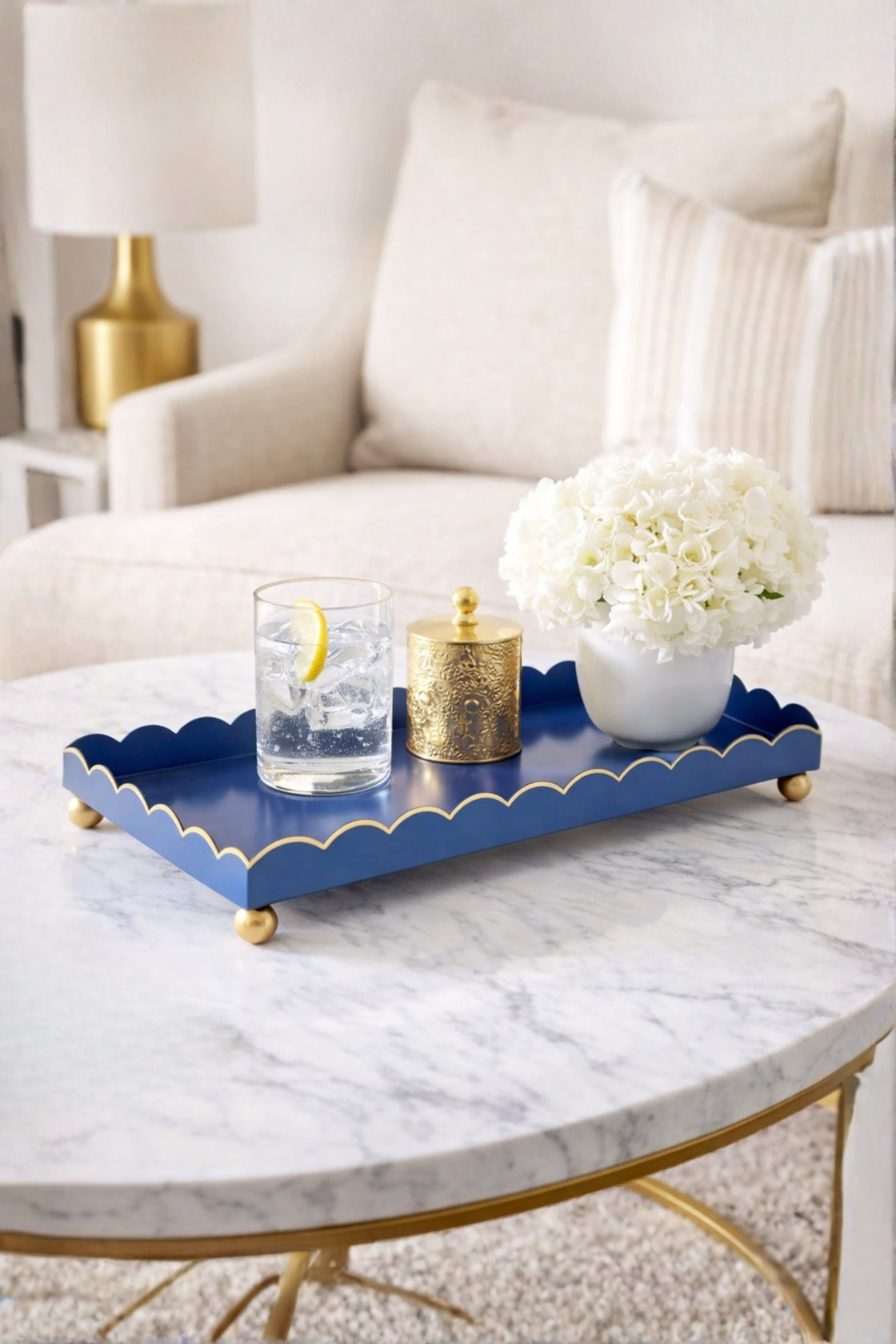 Navy blue tray with decorative items on a marble table in a living room setting.