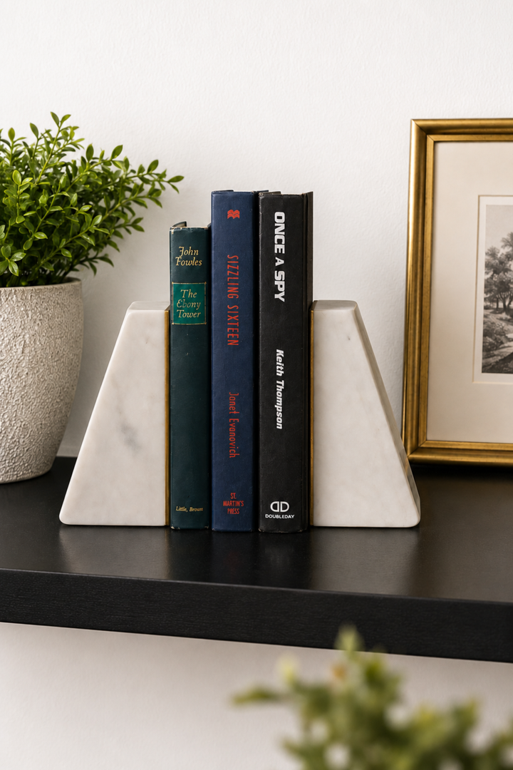 White marble angled bookends with brass inlay holding books upright