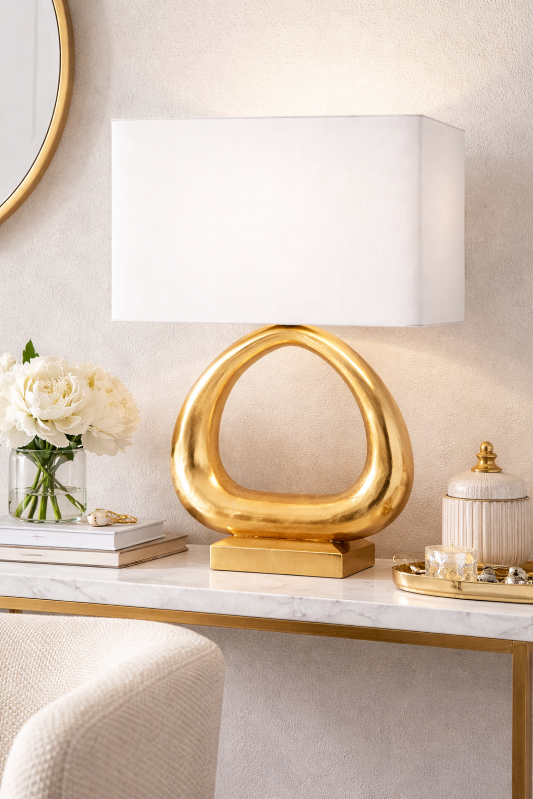 Gold table lamp on a marble surface with decorative items