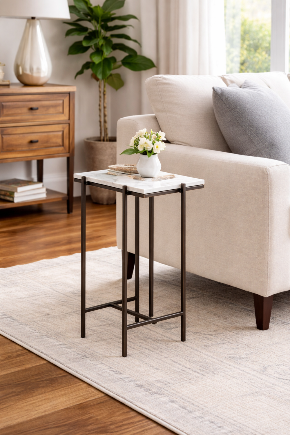Small side table with a white marble top in a living room setting.