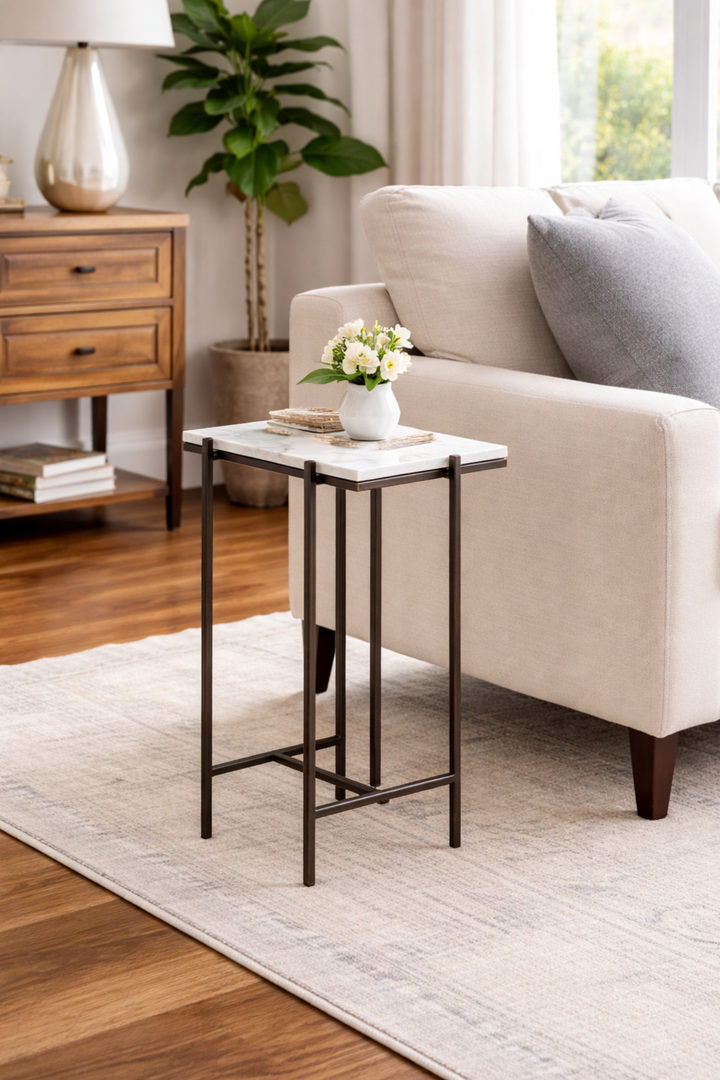 Small side table with a white marble top in a living room setting.