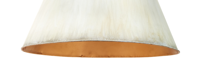 Close-up of a metal pendant with a brushed cream exterior and a gold interior, shown against a plain white background.