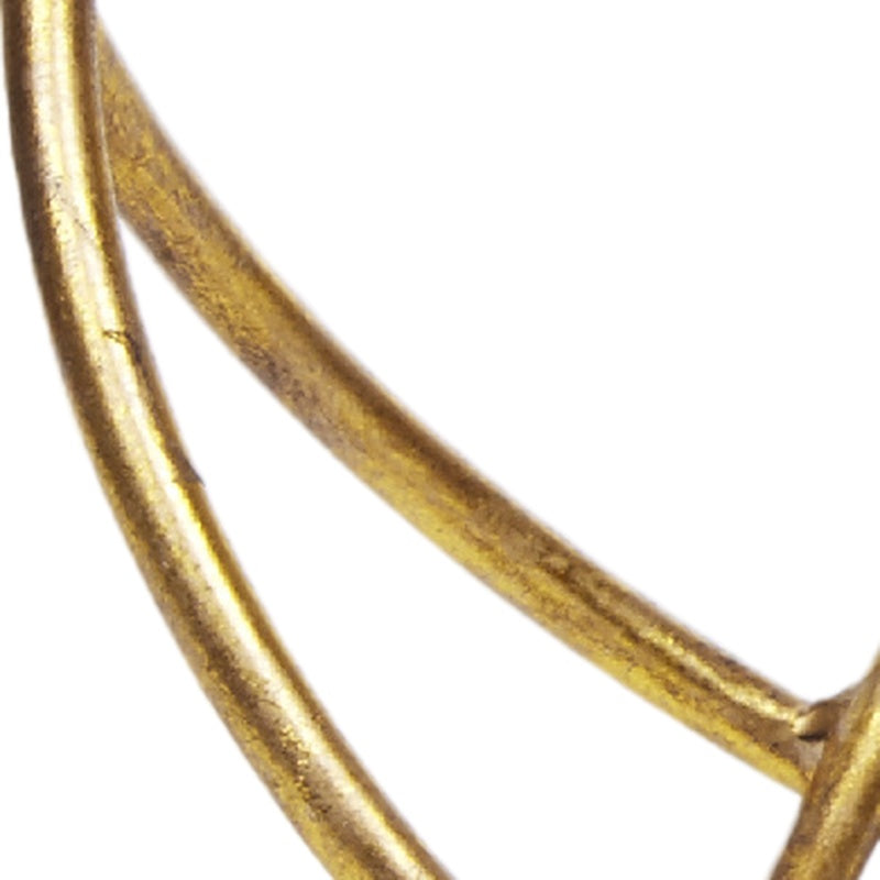 Gold decorative metal orb detail with two curved arcs and glossy finish
