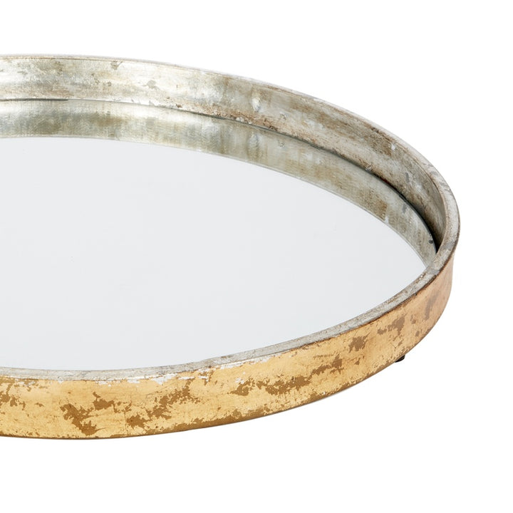 Round mirrored metal tray close-up of gold outer rim and silver reflective border