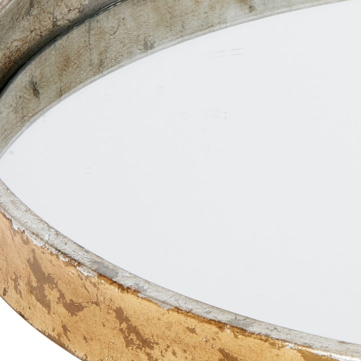 Round mirrored metal tray detail: worn gold outer finish with silver inner edge