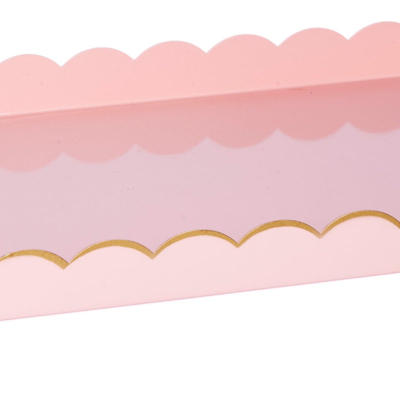 Blush pink rectangular metal tray with gold scalloped trim along top edge