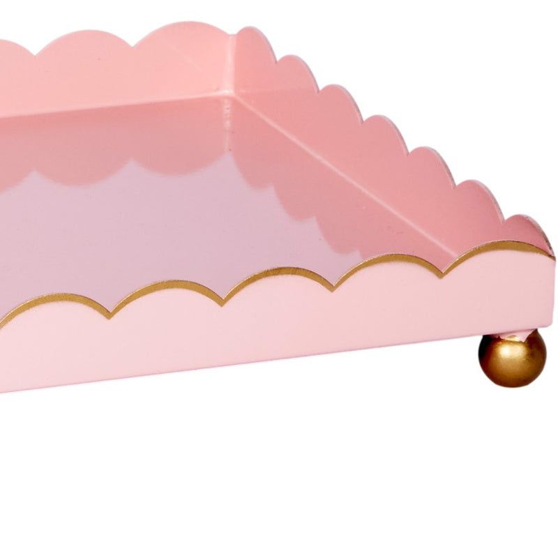 Blush pink rectangular metal tray with gold scalloped rim and round gold corner foot