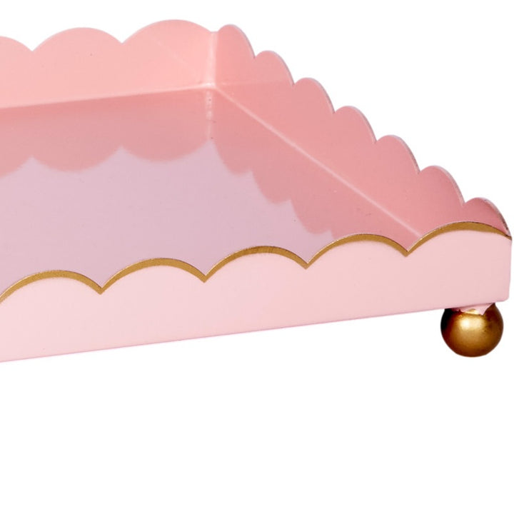 Blush pink rectangular metal tray with gold scalloped rim and round gold corner foot