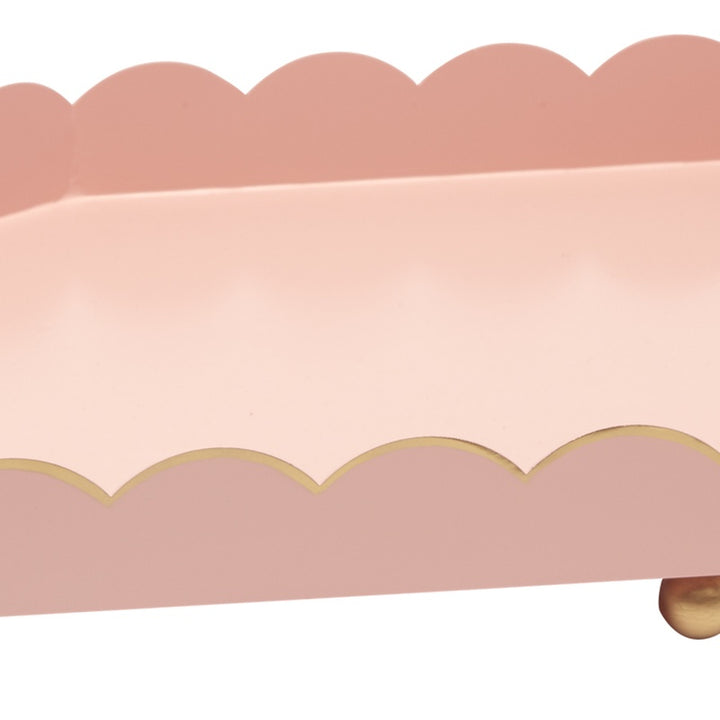 Pink metal tray with scalloped edge and gold rim, shown from side