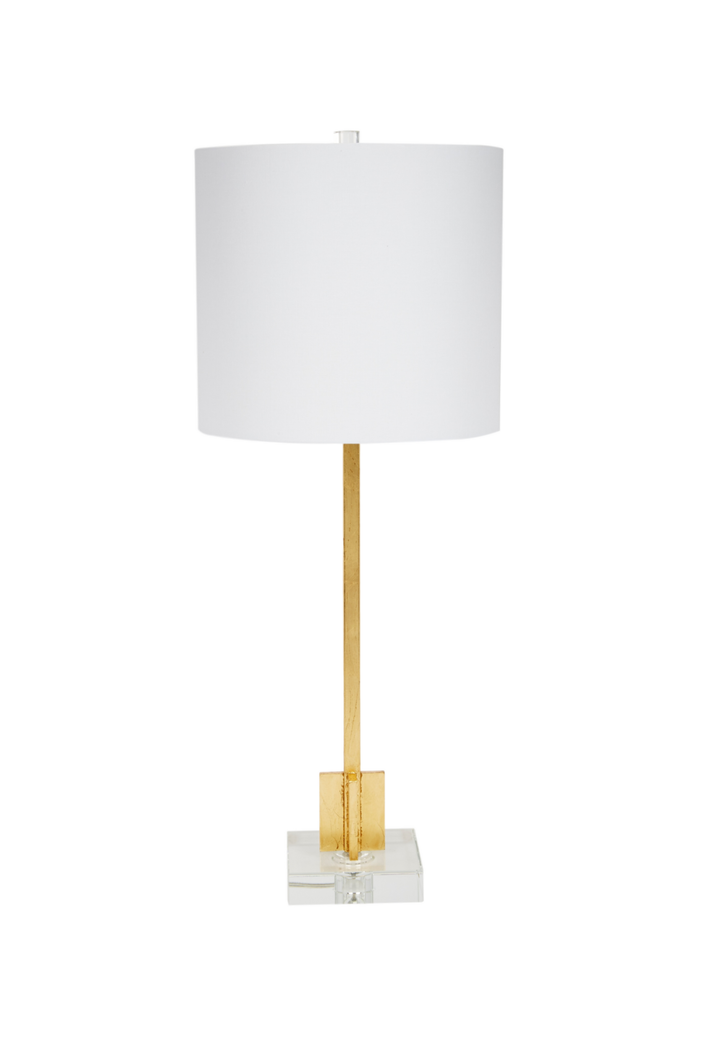 Modern table lamp with white drum shade, slim gold metal base, and clear acrylic square platform, minimalist luxury home lighting.