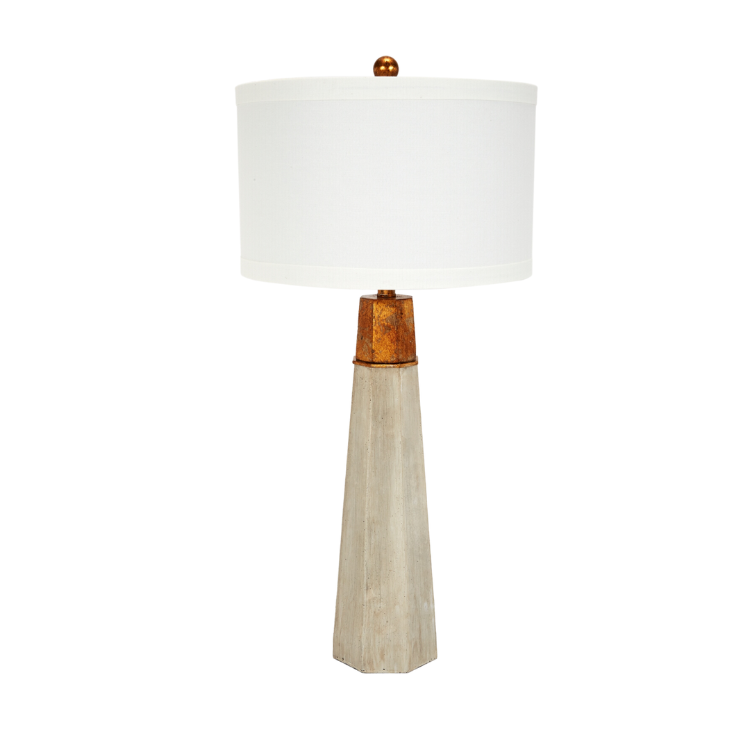 Contemporary table lamp with white drum shade, rustic gold accent, and tall tapered stone-look base for modern farmhouse and luxury home decor lighting